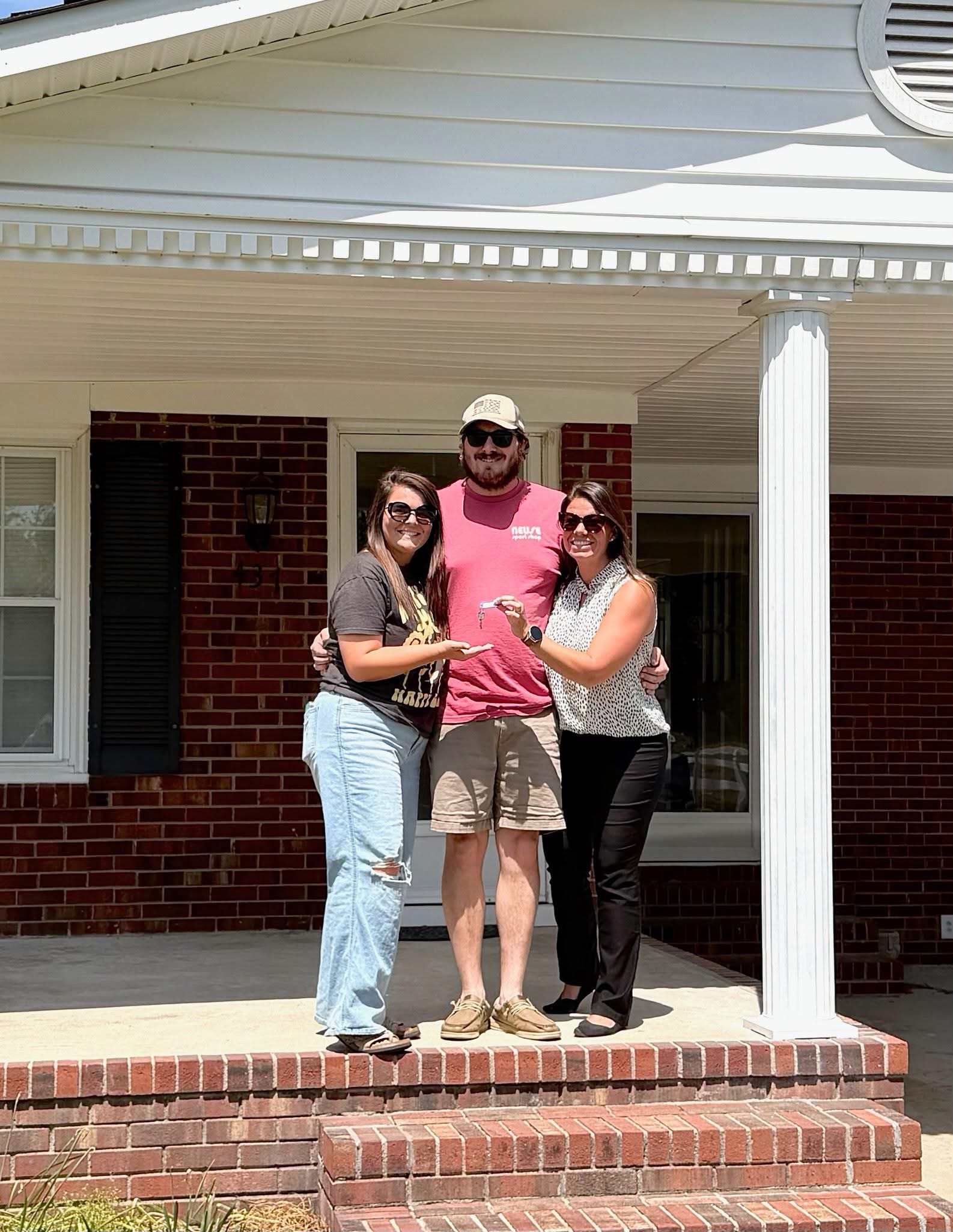 Happy buyers receiving keys to their new home from Ashley